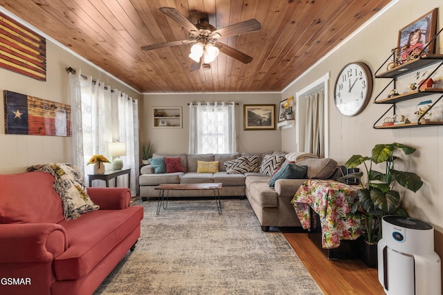 living room featuring ceiling fan, wood finished floors, wood ceiling, and ornamental molding