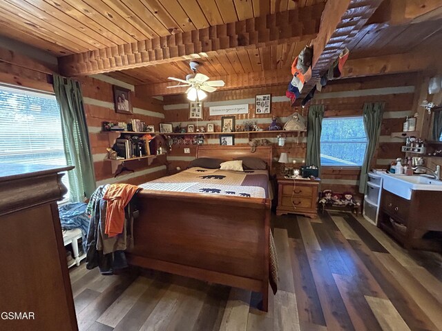 bedroom with wood walls, beamed ceiling, wooden ceiling, and dark hardwood / wood-style floors