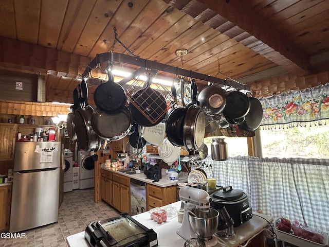 kitchen featuring washer and dryer, decorative light fixtures, and appliances with stainless steel finishes