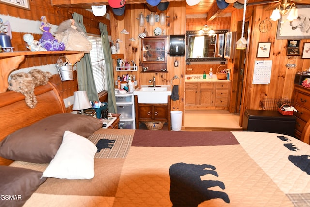 bedroom with wood walls and sink