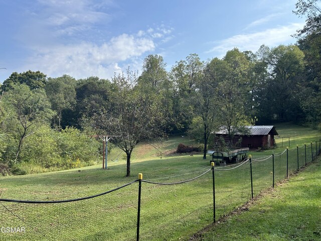 view of yard with a rural view and an outdoor structure