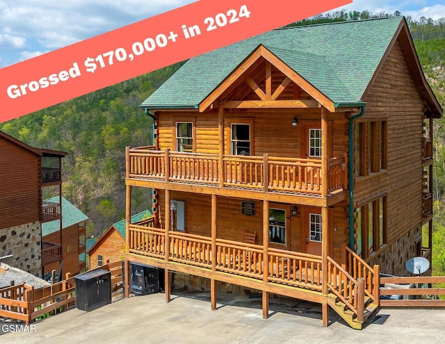 1232 Bird Nest Way, Sevierville, TN 37862 - view of front of house with a balcony, log exterior, roof with shingles, and a view of trees
