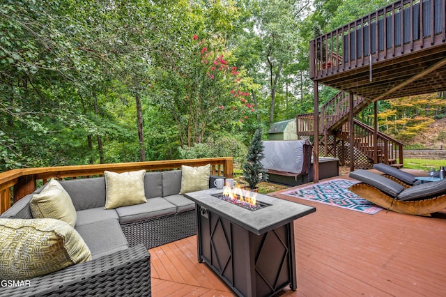 wooden deck featuring an outdoor living space with a fire pit