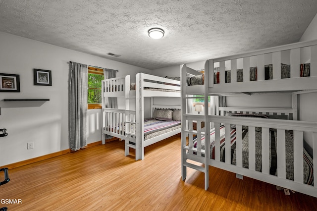 bedroom with wood-type flooring and a textured ceiling