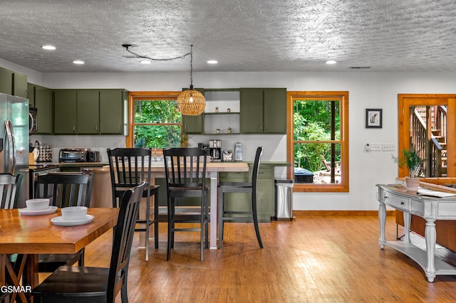 kitchen with backsplash, plenty of natural light, and green cabinets