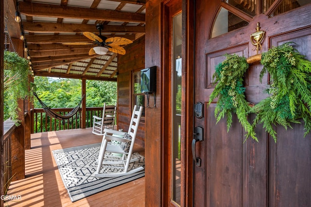 entrance to property featuring ceiling fan and a porch