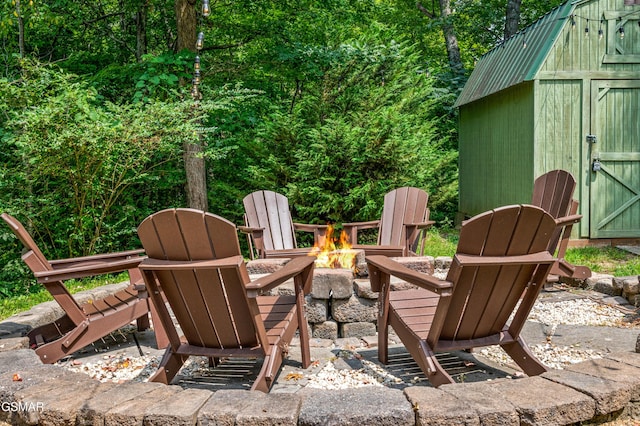 view of patio / terrace featuring a shed and an outdoor fire pit