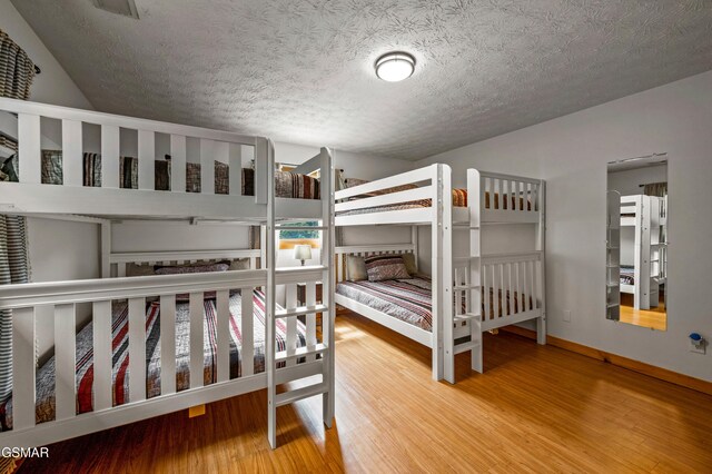 bedroom with hardwood / wood-style floors and a textured ceiling