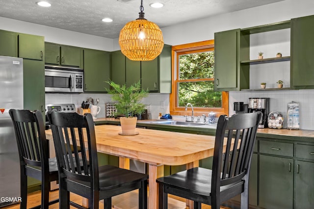 kitchen featuring backsplash, sink, a textured ceiling, and green cabinetry