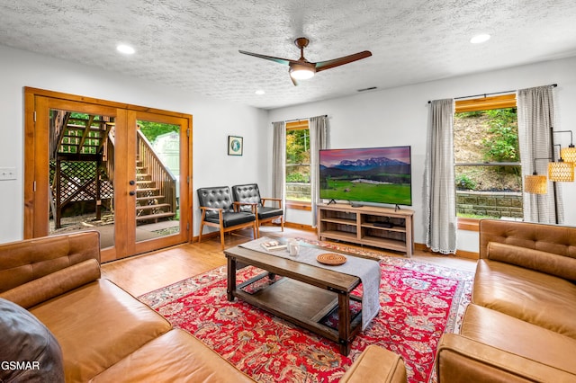 living room with a textured ceiling, hardwood / wood-style flooring, and a healthy amount of sunlight