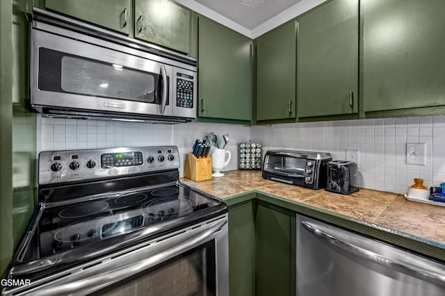 kitchen with backsplash, stainless steel appliances, and green cabinetry