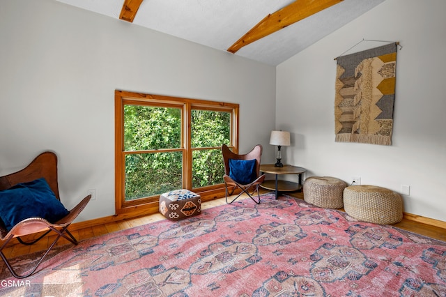 living area with lofted ceiling with beams and wood-type flooring