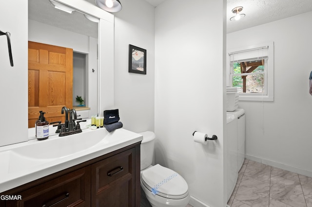 bathroom with a textured ceiling, vanity, and toilet