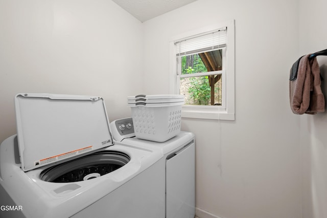 laundry room featuring a textured ceiling and washing machine and clothes dryer