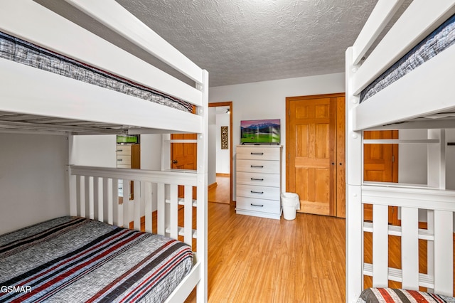 bedroom featuring light hardwood / wood-style flooring and a textured ceiling