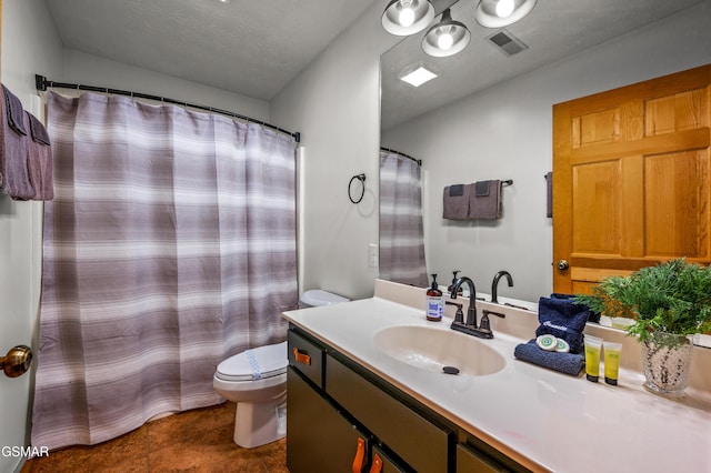 bathroom featuring tile patterned floors, vanity, a textured ceiling, and toilet