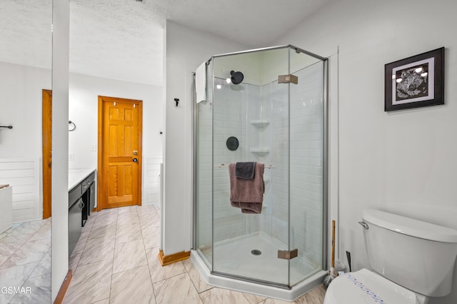 bathroom with vanity, toilet, an enclosed shower, and a textured ceiling