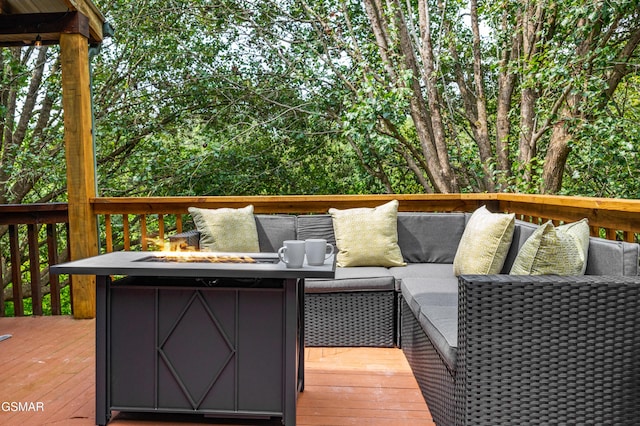 deck featuring an outdoor living space with a fire pit