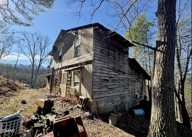 view of home's exterior with cooling unit and stucco siding