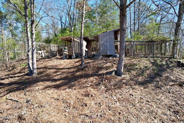 view of yard featuring an outbuilding, fence, and exterior structure