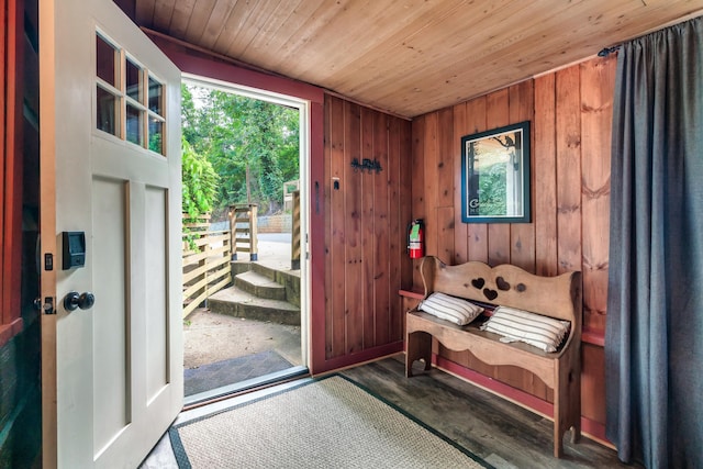 entrance foyer with wooden walls, dark wood-type flooring, and wood ceiling