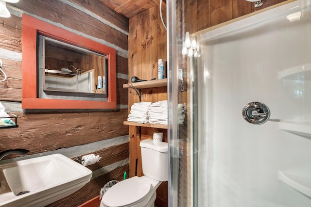 bathroom featuring toilet, wooden walls, sink, and walk in shower