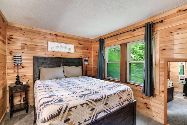 carpeted bedroom featuring wood walls and a textured ceiling