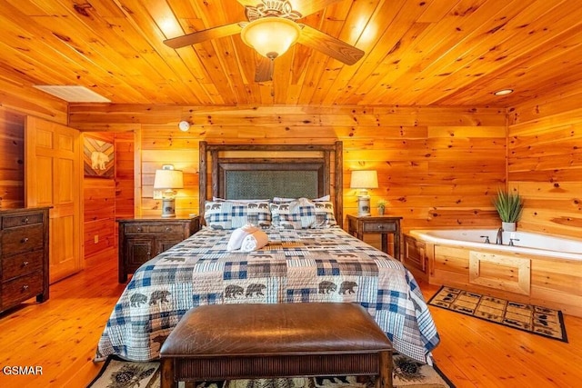 bedroom with wooden ceiling, light hardwood / wood-style flooring, ceiling fan, and wooden walls