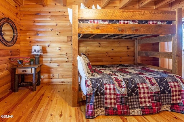 bedroom featuring light hardwood / wood-style floors and log walls