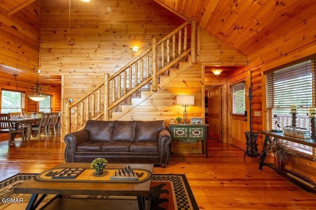 living room featuring a healthy amount of sunlight, log walls, wood ceiling, and hardwood / wood-style flooring