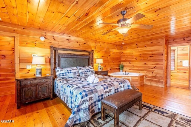 bedroom with ceiling fan, light hardwood / wood-style flooring, wooden ceiling, and wood walls