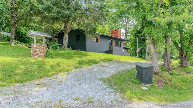 1920 Inskip Ln, Dandridge, TN 37725 - view of home's exterior with a chimney, concrete block siding, driveway, and a lawn