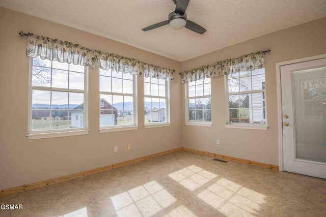 interior space with visible vents and ceiling fan