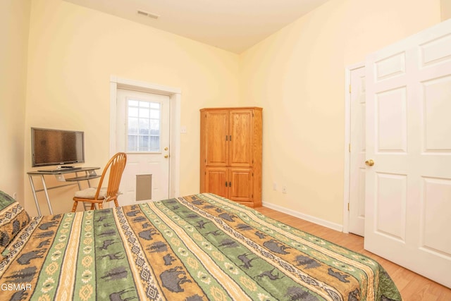 bedroom with light wood-style floors, baseboards, and visible vents