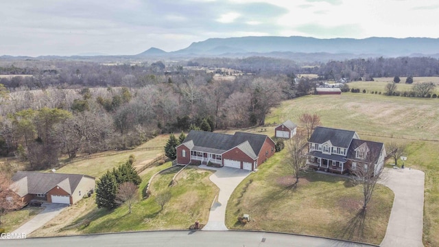 birds eye view of property featuring a forest view, a rural view, and a mountain view