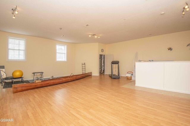 workout area featuring light wood-style flooring and baseboards