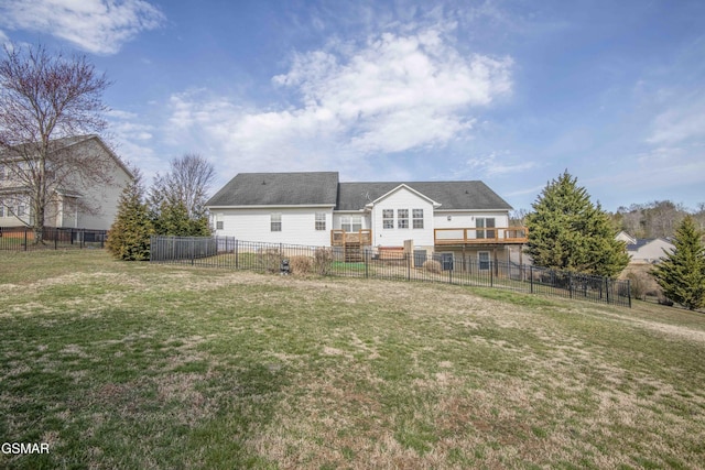 rear view of house with a fenced backyard and a yard