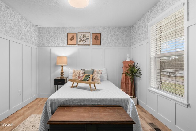 bedroom featuring multiple windows and light hardwood / wood-style flooring