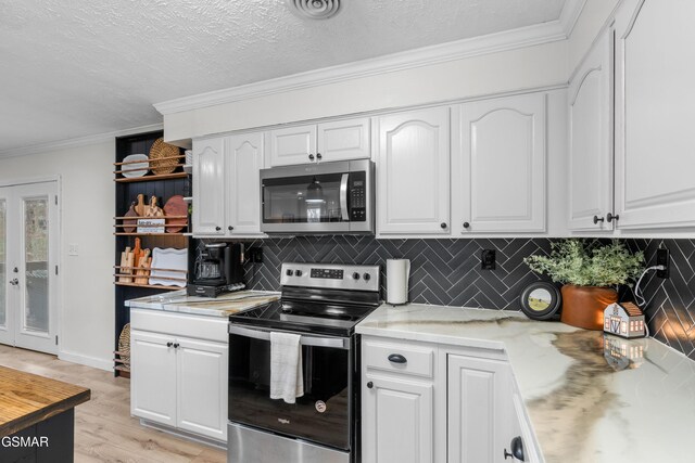 kitchen featuring white cabinets, a textured ceiling, appliances with stainless steel finishes, and tasteful backsplash