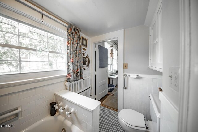294 Clifton Heights Rd, Newport, TN 37821 - bathroom with tile walls, wainscoting, a bathing tub, toilet, and radiator