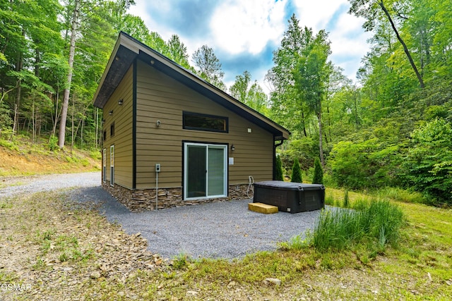 5145 E Parkway Pkwy, Cosby, TN 37722 - rear view of property featuring a hot tub, stone siding, and a patio area
