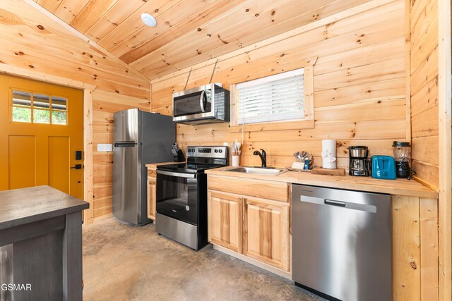 5145 E Parkway Pkwy, Cosby, TN 37722 - kitchen featuring stainless steel appliances, lofted ceiling, concrete flooring, wooden walls, and light brown cabinets
