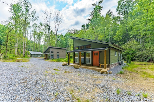 5145 E Parkway Pkwy, Cosby, TN 37722 - view of front facade with gravel driveway, a porch, and a forest view