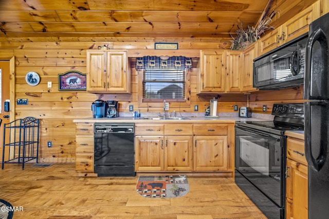 kitchen with wood ceiling, sink, black appliances, light hardwood / wood-style flooring, and wood walls