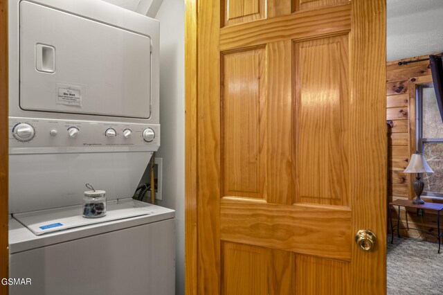 clothes washing area featuring stacked washer / drying machine