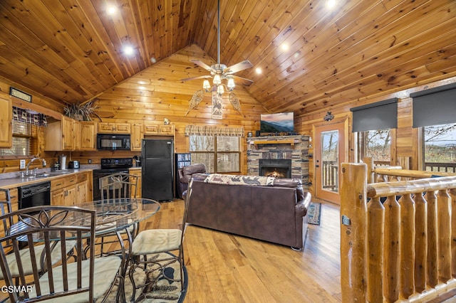 living room with light hardwood / wood-style flooring, a stone fireplace, wooden ceiling, and sink