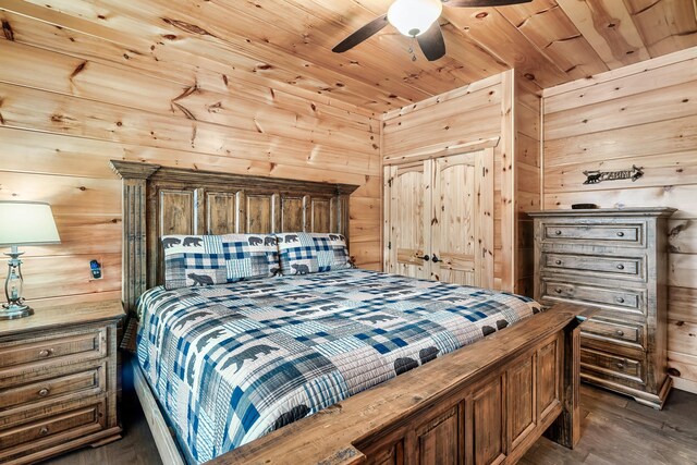 bedroom featuring dark hardwood / wood-style floors, ceiling fan, wooden walls, and wood ceiling