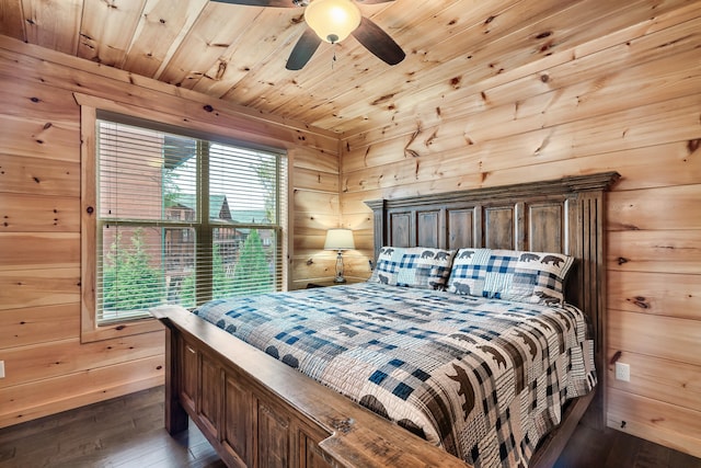 bedroom with wooden walls, ceiling fan, and dark hardwood / wood-style floors