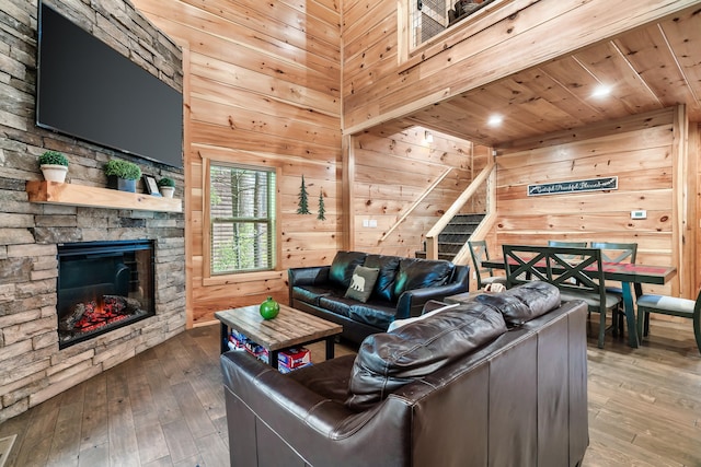 living room featuring wooden walls, a fireplace, wooden ceiling, and wood-type flooring