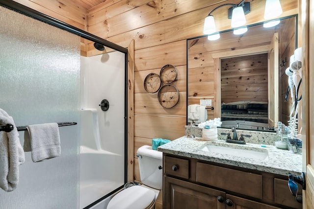 bathroom featuring vanity, toilet, a shower with shower door, and wood walls